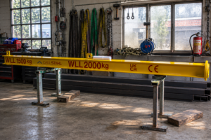 A photo of the variable weight lifting beam sat inside of a workshop