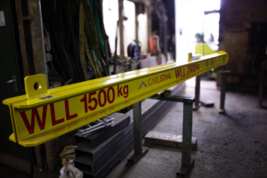 A photo showing the Variable Weight lifting beam from its length side, the Beam has both WLL present and is Carl Stahl Branded